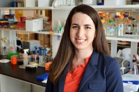 Allison Lau, with a lab bench behind her