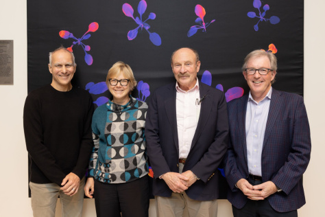 Three men and one woman smiling for the camera